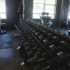 dumbbell rack in front. of large mirror in the gym space